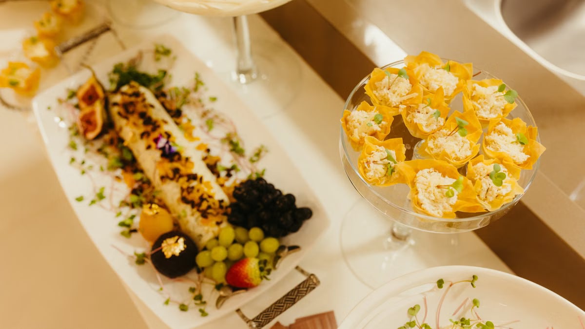 A sophisticated arrangement of gourmet appetizers featuring fresh fruits and savory bites on elegant platters.